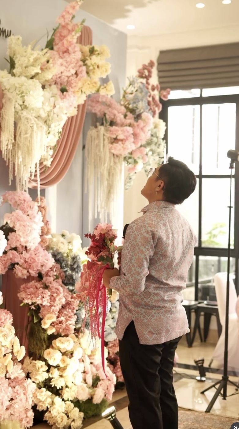 Tim dekorasi menyiapkan rangkaian bunga pelaminan