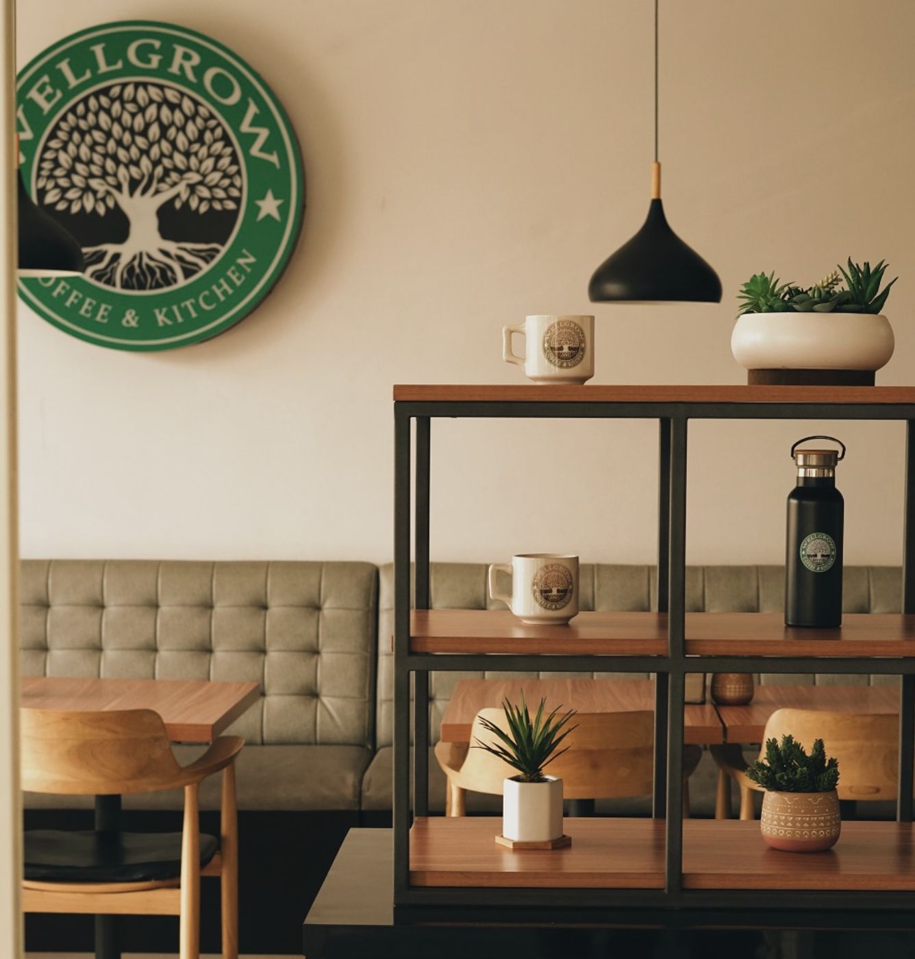 Sudut duduk Wellgrow dengan logo pohon di dinding