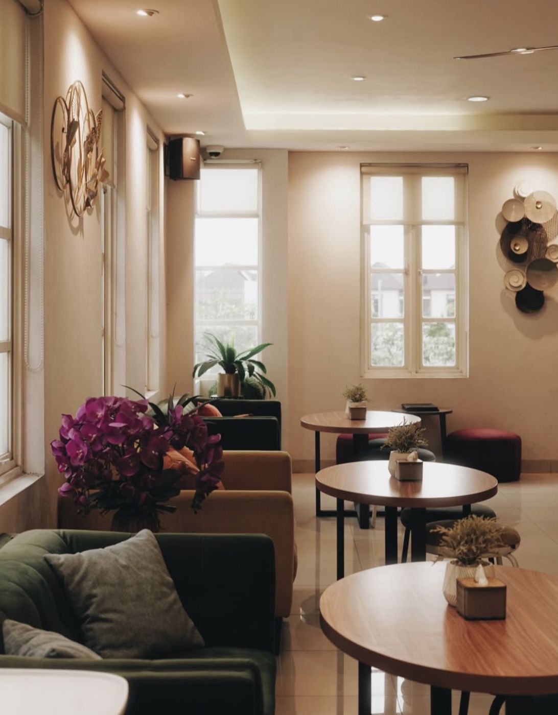 Lounge lantai dua dengan sofa, meja bundar, dan anggrek ungu